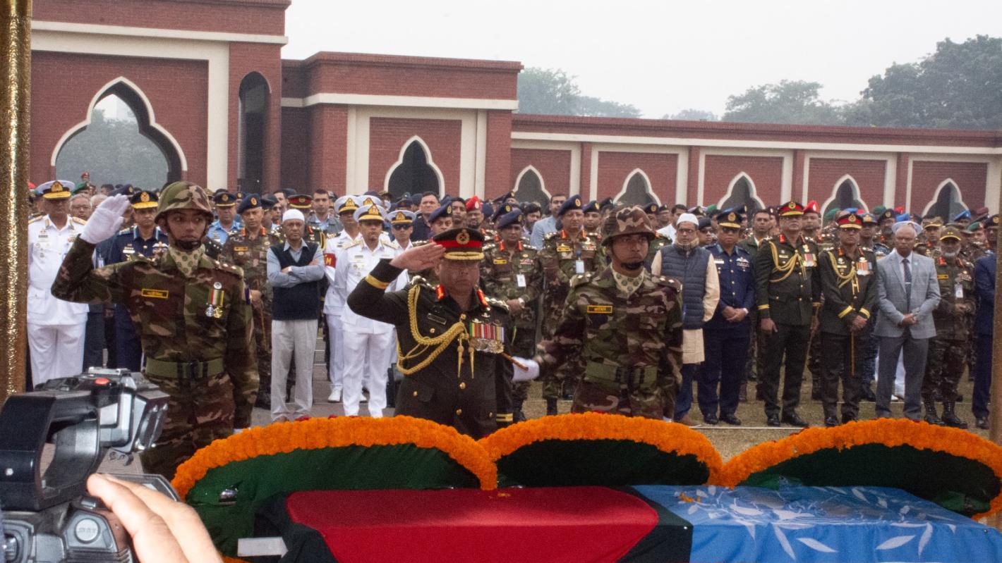 A group of soldiers stand saluting 