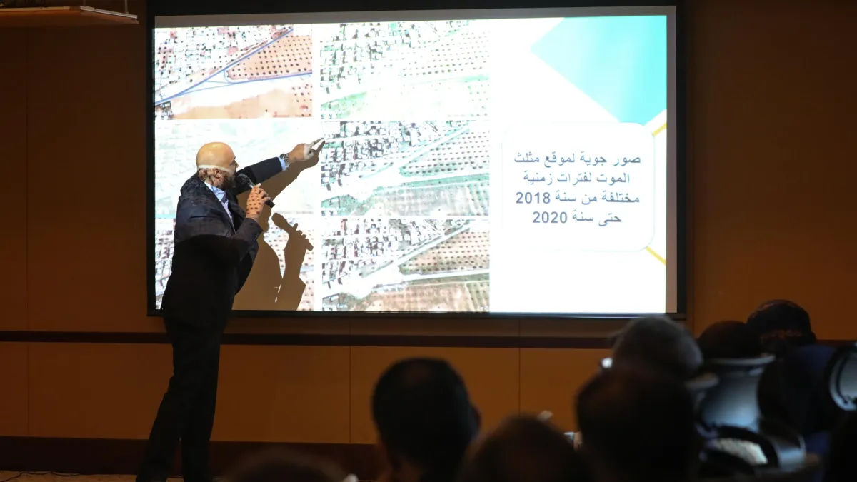 A man presenting a satellite photo for potential mass grave site 