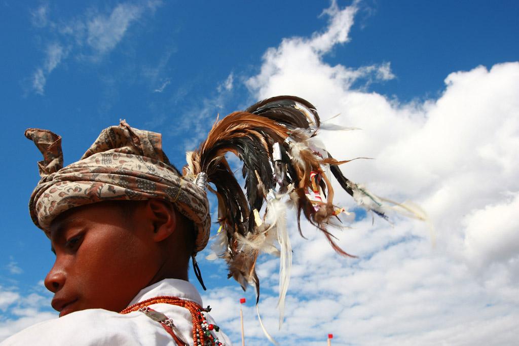 Man wears the traditional manu-fulun headdress made of rooster feathers.